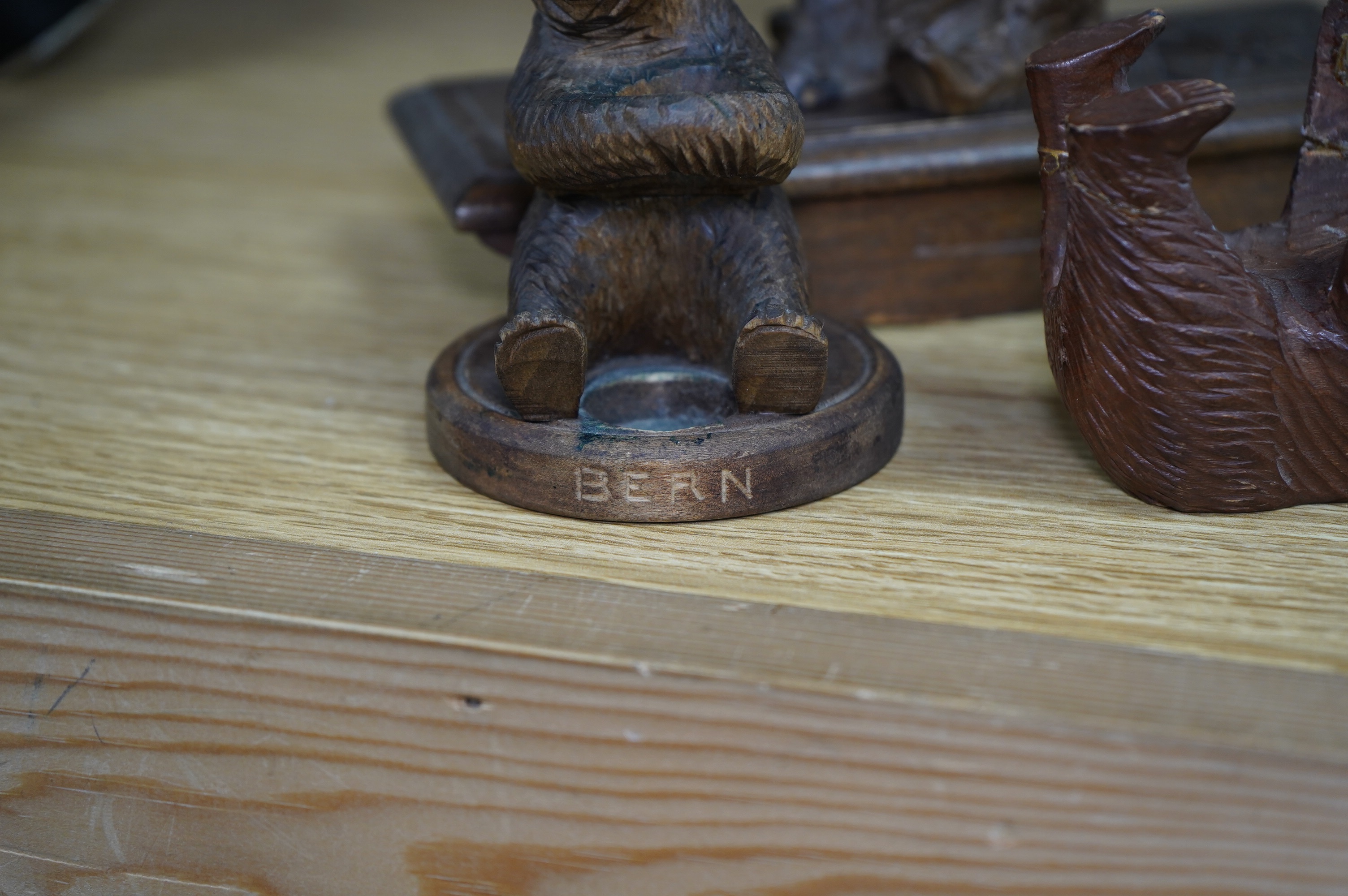 Five carved Black Forest bears, two in the form of ink blotters, together with an African figure of a hippopotamus, largest 17cm wide. Condition - poor to fair